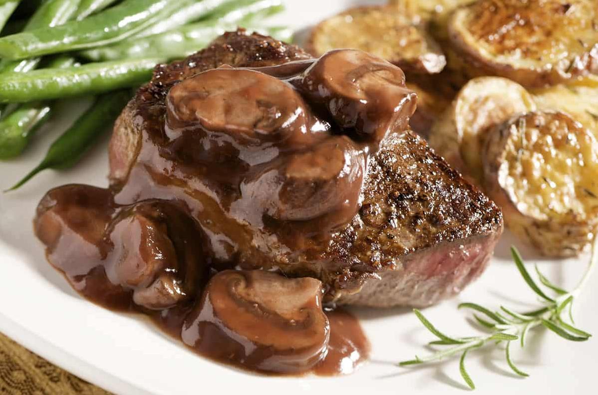  A sizzling and savory steak topped with a rich and flavorful mushroom and red wine sauce