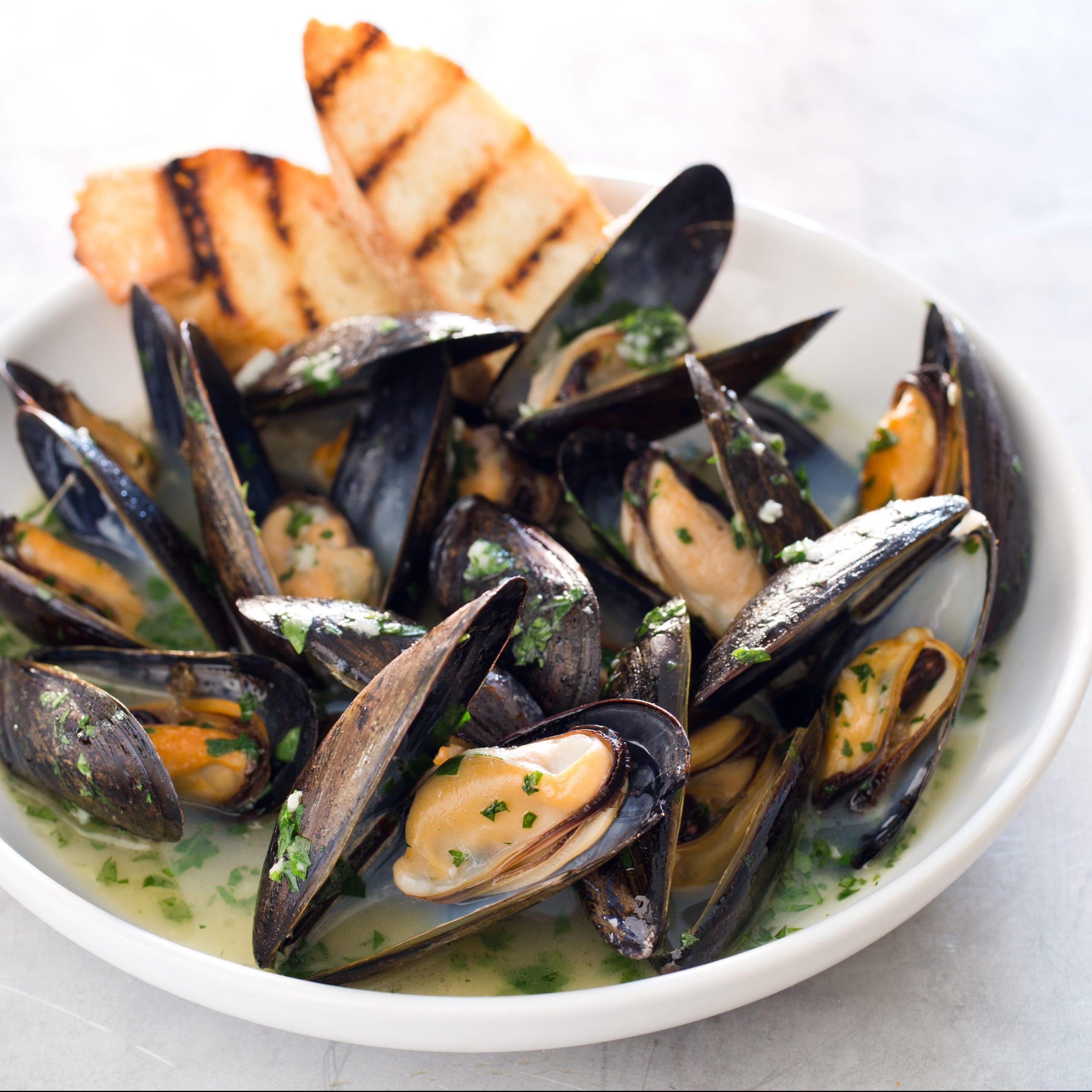 A warm loaf of crusty bread is perfect for soaking up the white wine and garlic broth these mussels sit in!