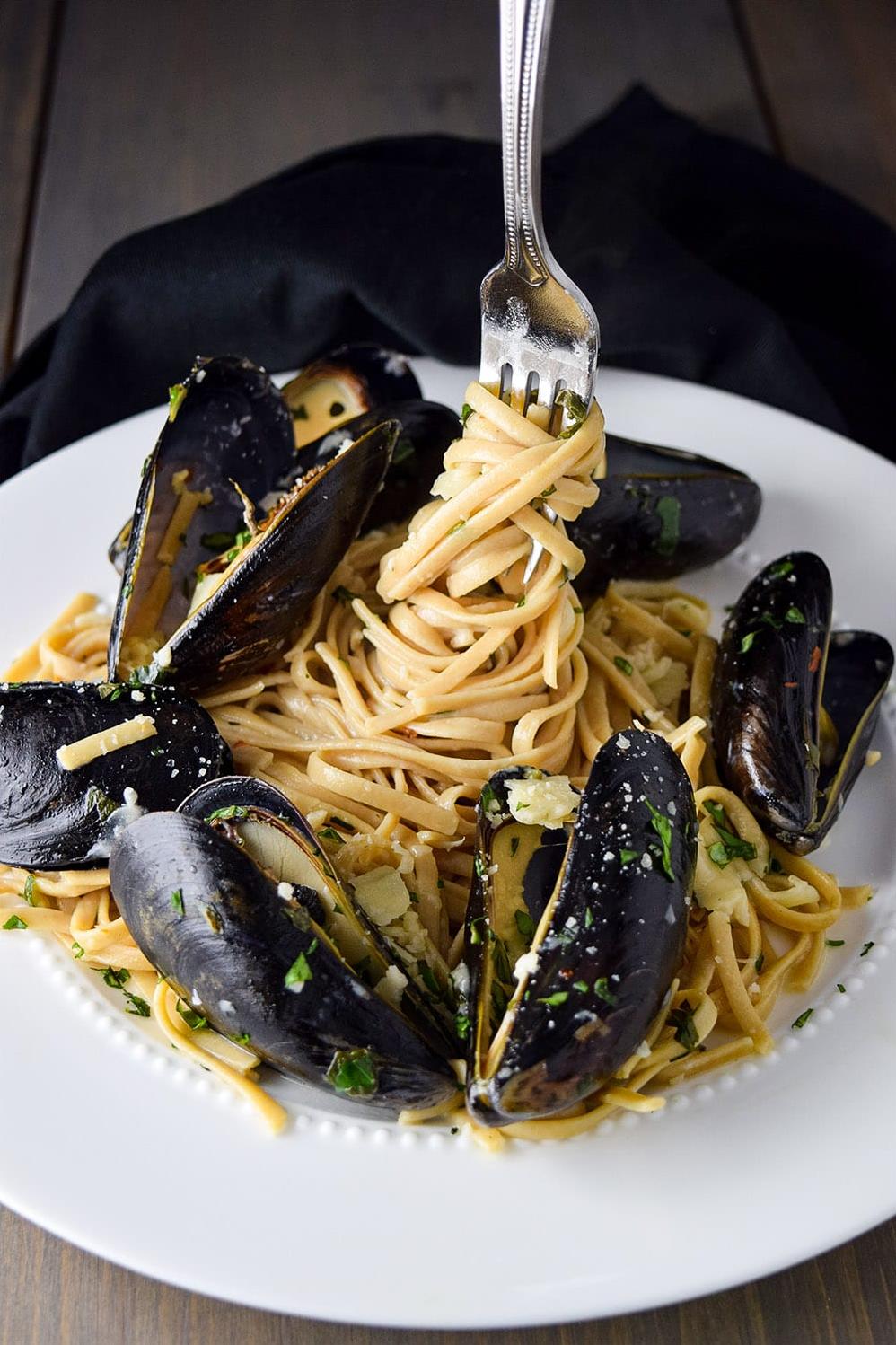  Spaghetti swimming in a flavorful pool of white wine and mussel sauce.