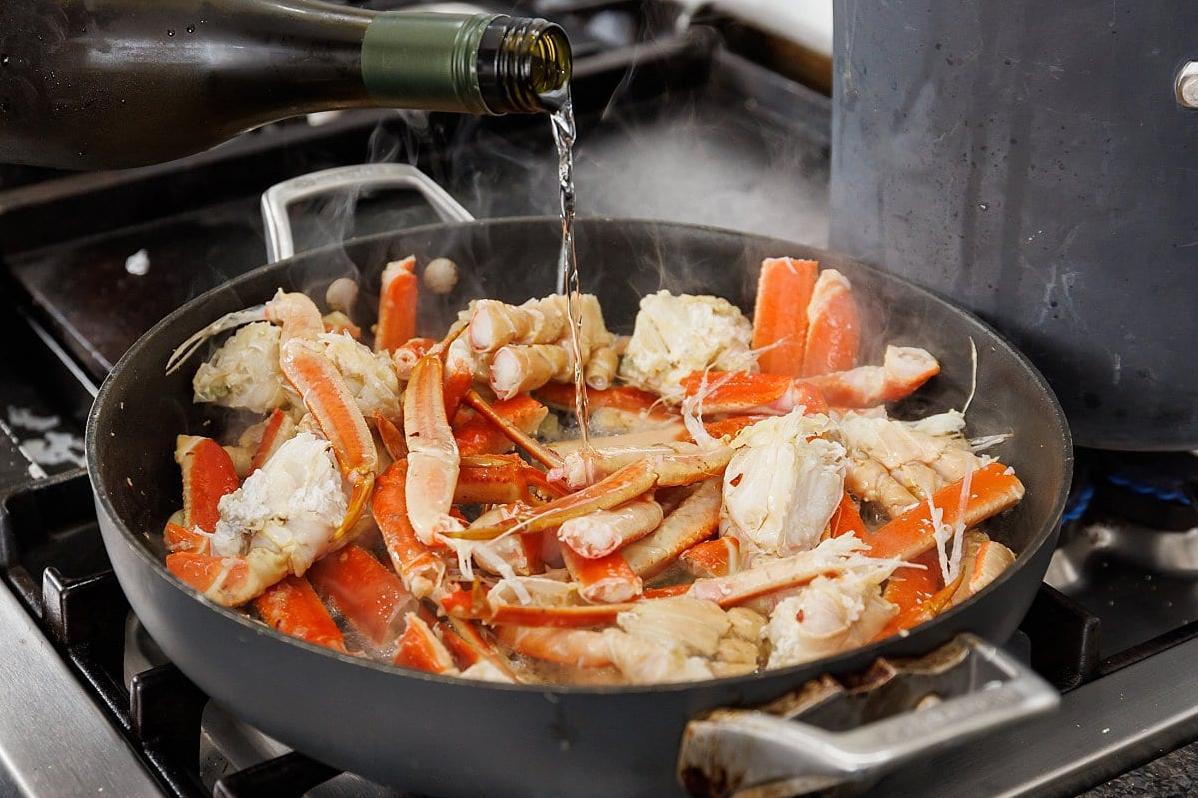  Succulent crab legs bathing in a sea of savory wine sauce.