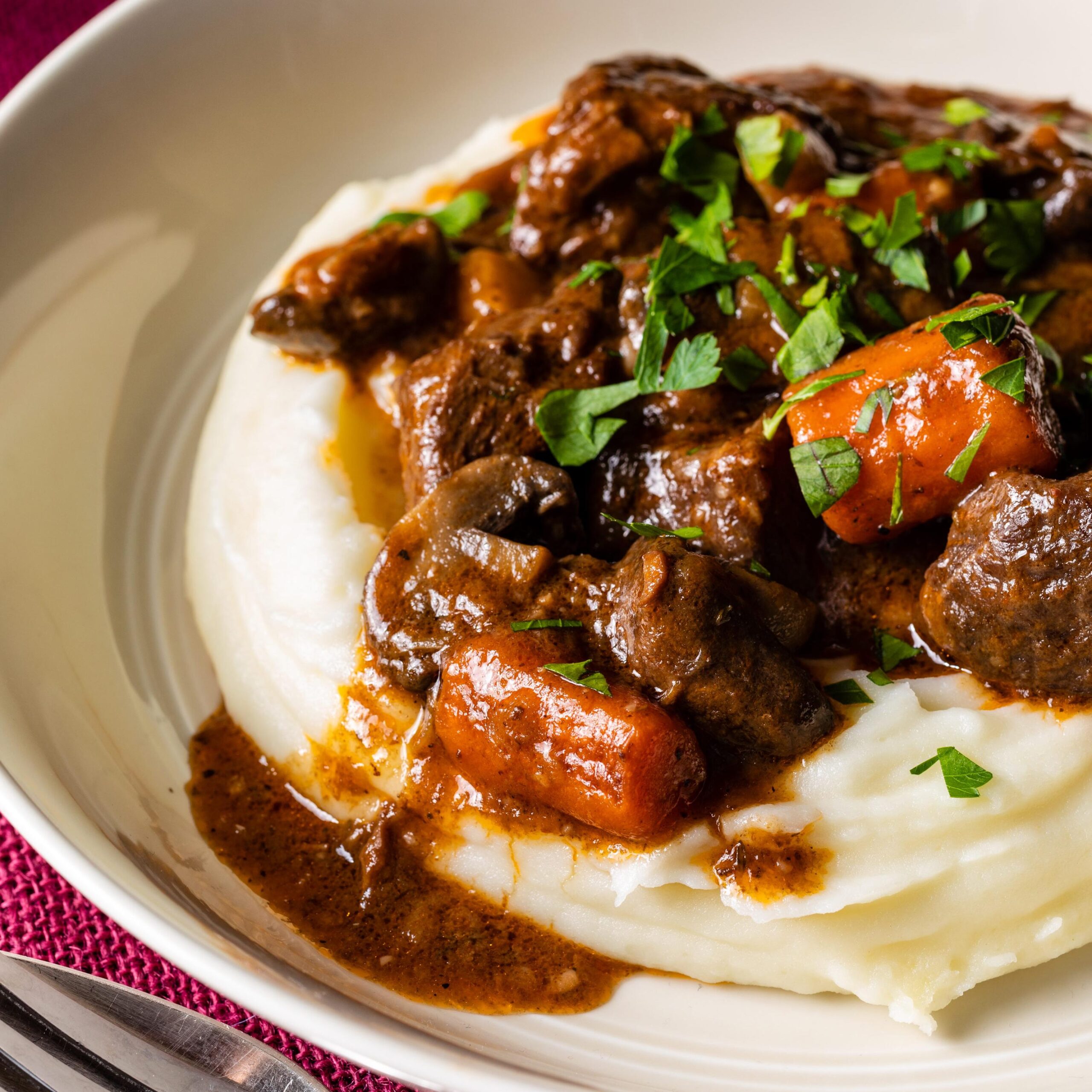  Tender chunks of beef are slowly simmered in a red wine and beef broth for hours.